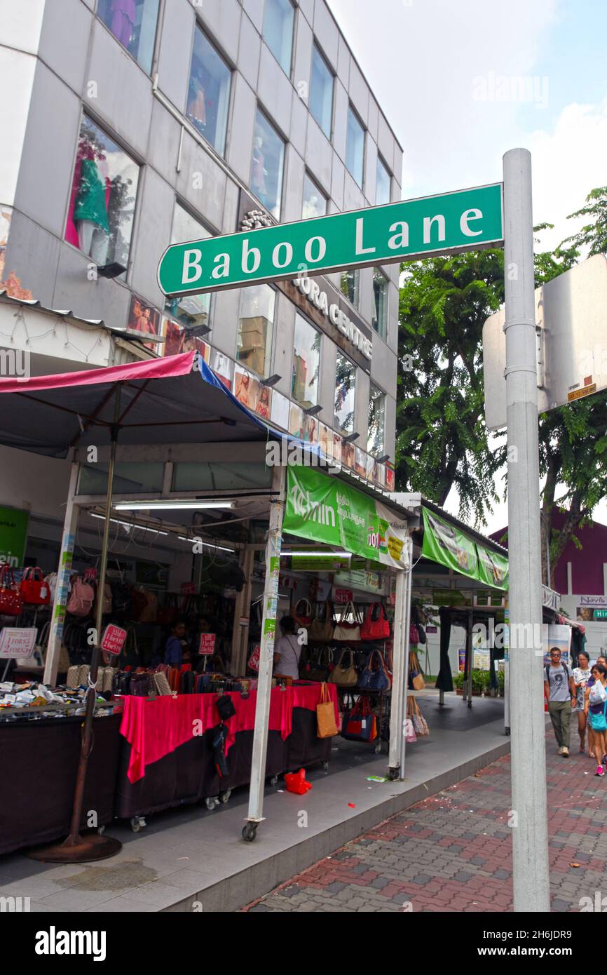 Un cartello verde con il nome della strada per Baboo Lane con l'edificio minora Center sullo sfondo di Serangoon Road a Little India, Singapore. Foto Stock