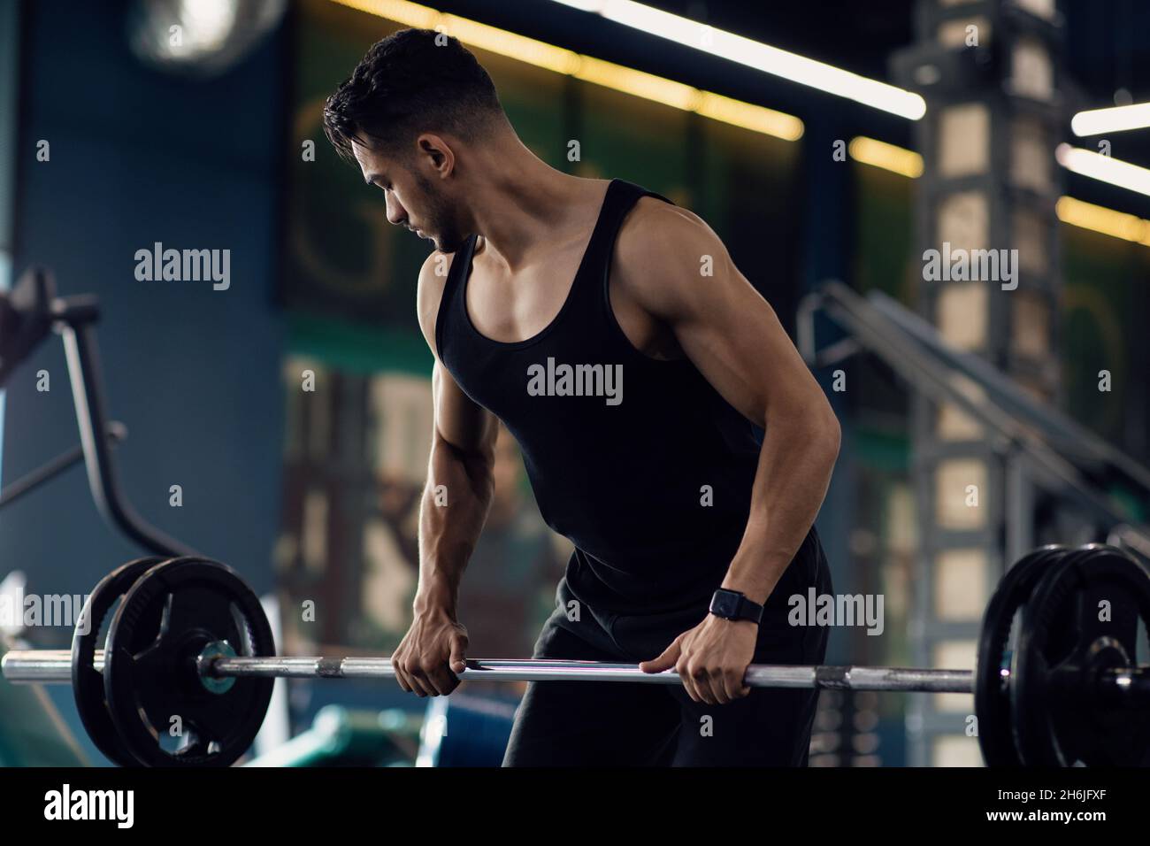 Muscular Middle Eastern Man fare deadlift esercizio di peso in palestra Foto Stock