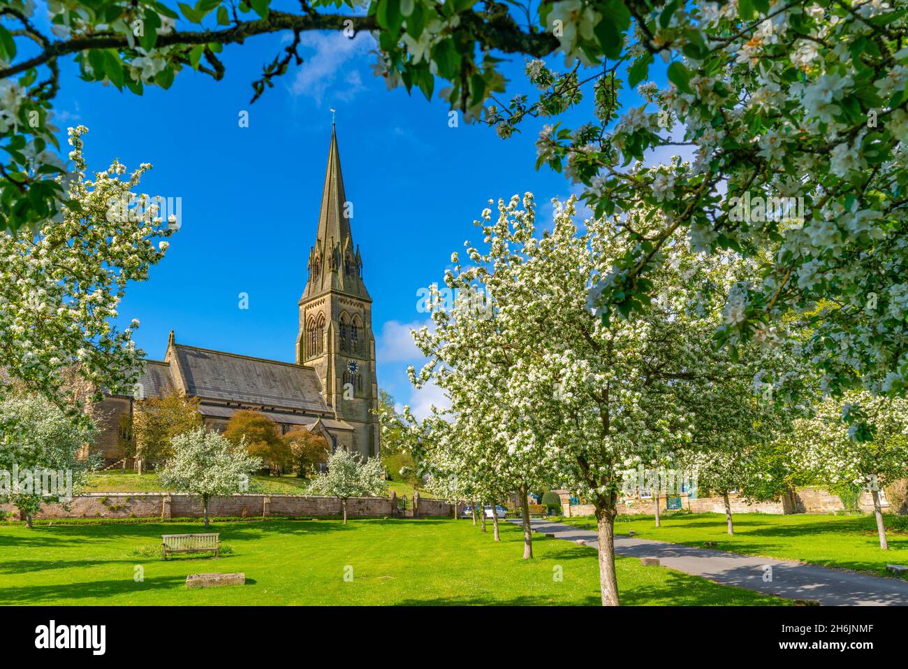 Vista della chiesa di San Pietro e della fioritura primaverile, Edensor Village, Chatsworth Park, Bakewell, Derbyshire, Inghilterra, Regno Unito, Europa Foto Stock