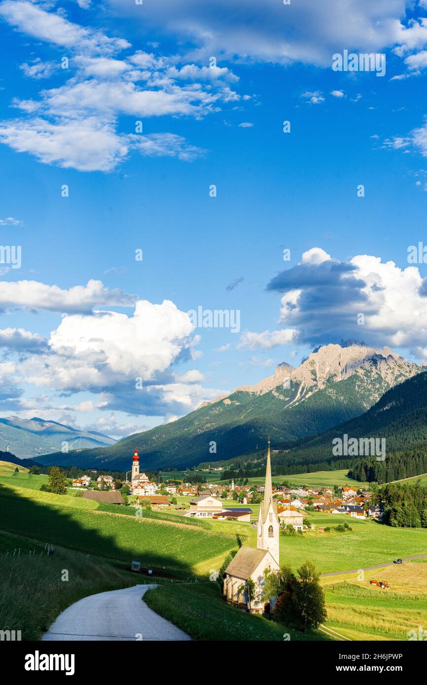 Sole su pascoli verdi e villaggio di Villabassa (Niederdorf) in estate, Val Pusteria, provincia di Bolzano, Alto Adige, Italia, Europa Foto Stock