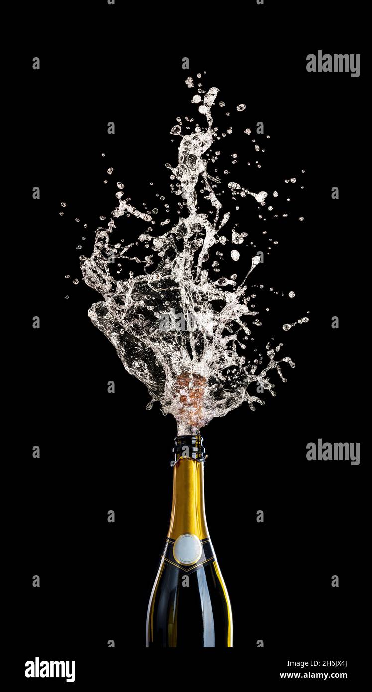bottiglia di champagne con sughero che vola con liquido spruzzante su nero. concetto di festa, festa. Foto Stock