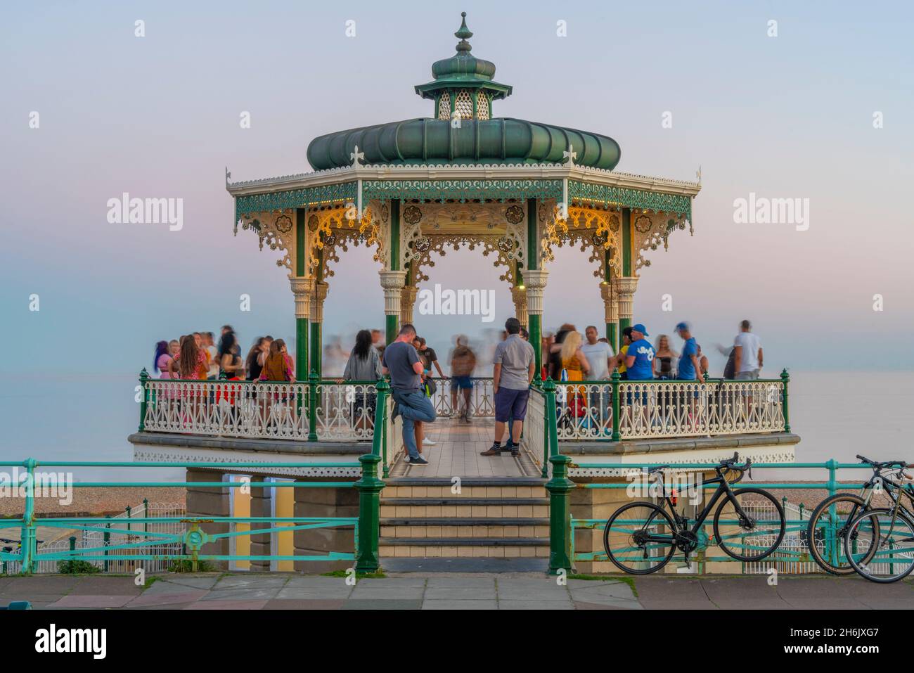 Vista della gente sul palco ornato sul fronte del mare al crepuscolo, Brighton, Sussex orientale, Inghilterra, Regno Unito, Europa Foto Stock