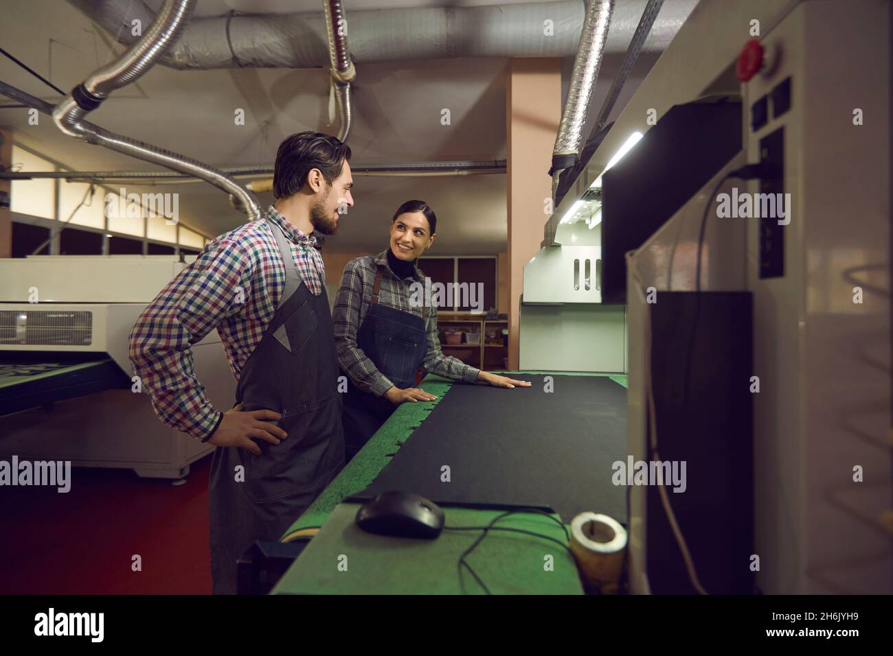 I dipendenti maschi e femmine di una fabbrica di scarpe comunicano tra loro in officina. Foto Stock