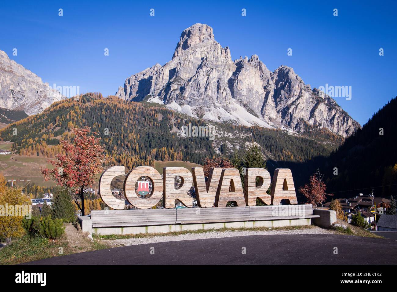 Il villaggio di montagna risort Corvara in Badia con una montagna enorme sullo sfondo Foto Stock