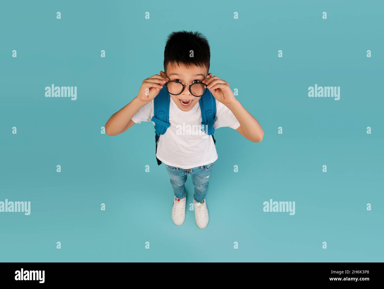Annuncio didattico Vista dall'alto di Funny shocked bambino asiatico in occhiali Foto Stock