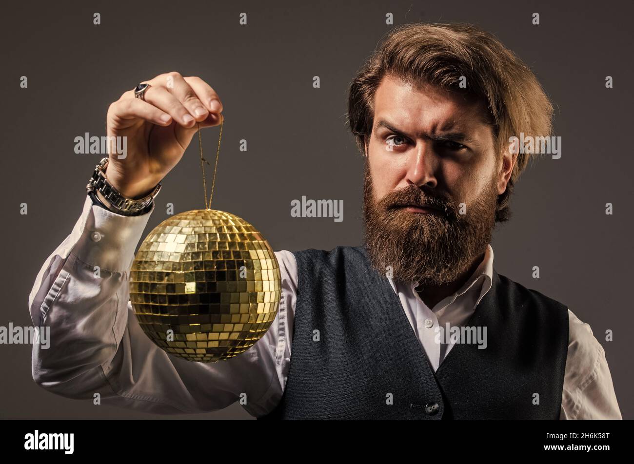 L'uomo maturo bearded tiene la sfera dorata della discoteca, concetto di vita di lusso Foto Stock