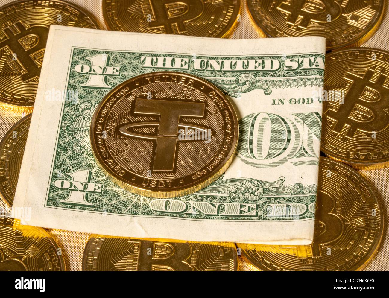 Concetto di moneta di Tether contro le monete bitcoin d'oro e una singola banconota o fattura del dollaro USA. Il laccio è sostenuto dal dollaro USA e usato per il commercio delle monete di alt Foto Stock