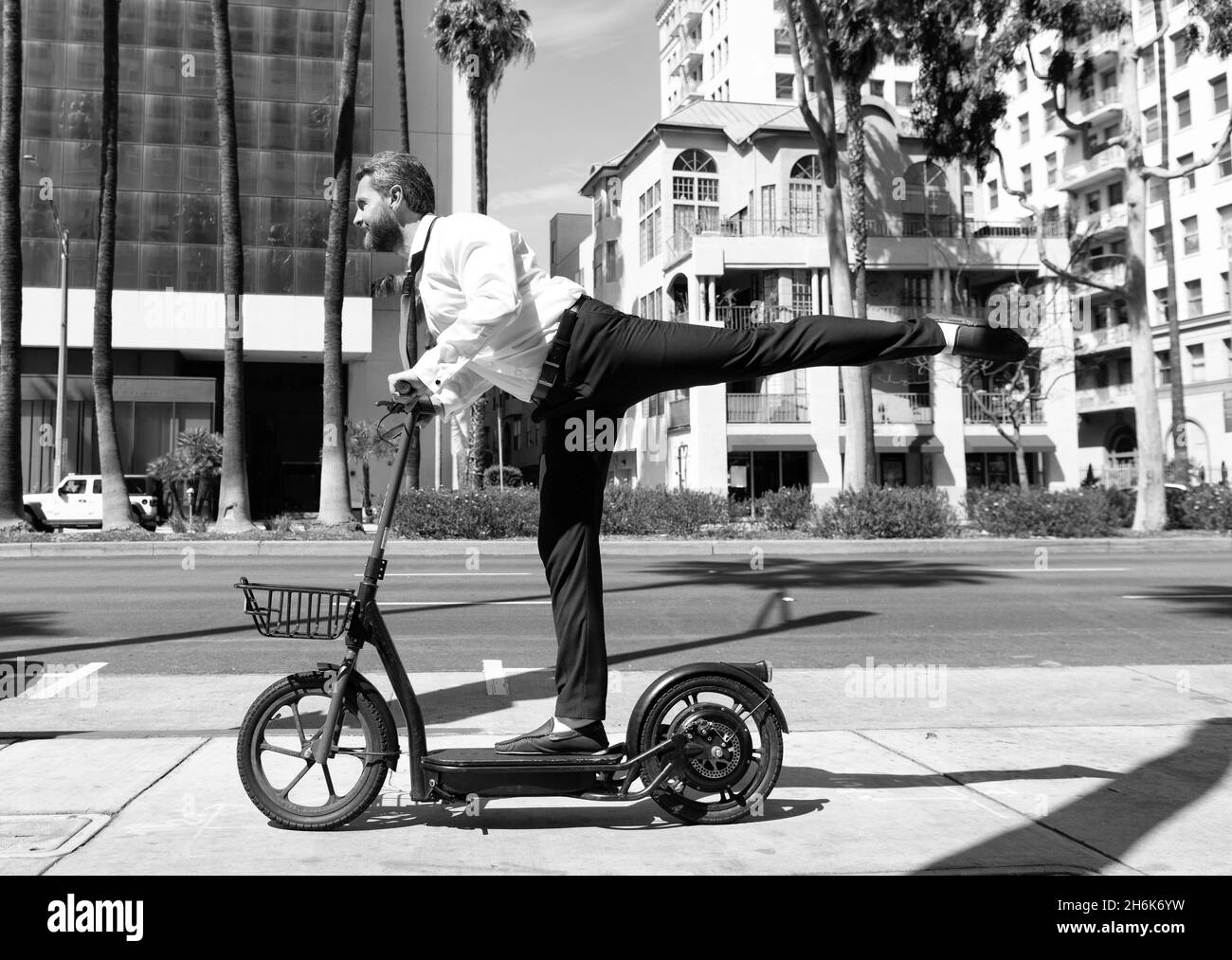 uomo d'affari su scooter elettrico. uomo che guida scossa scooter. trasporto ecologico. Foto Stock
