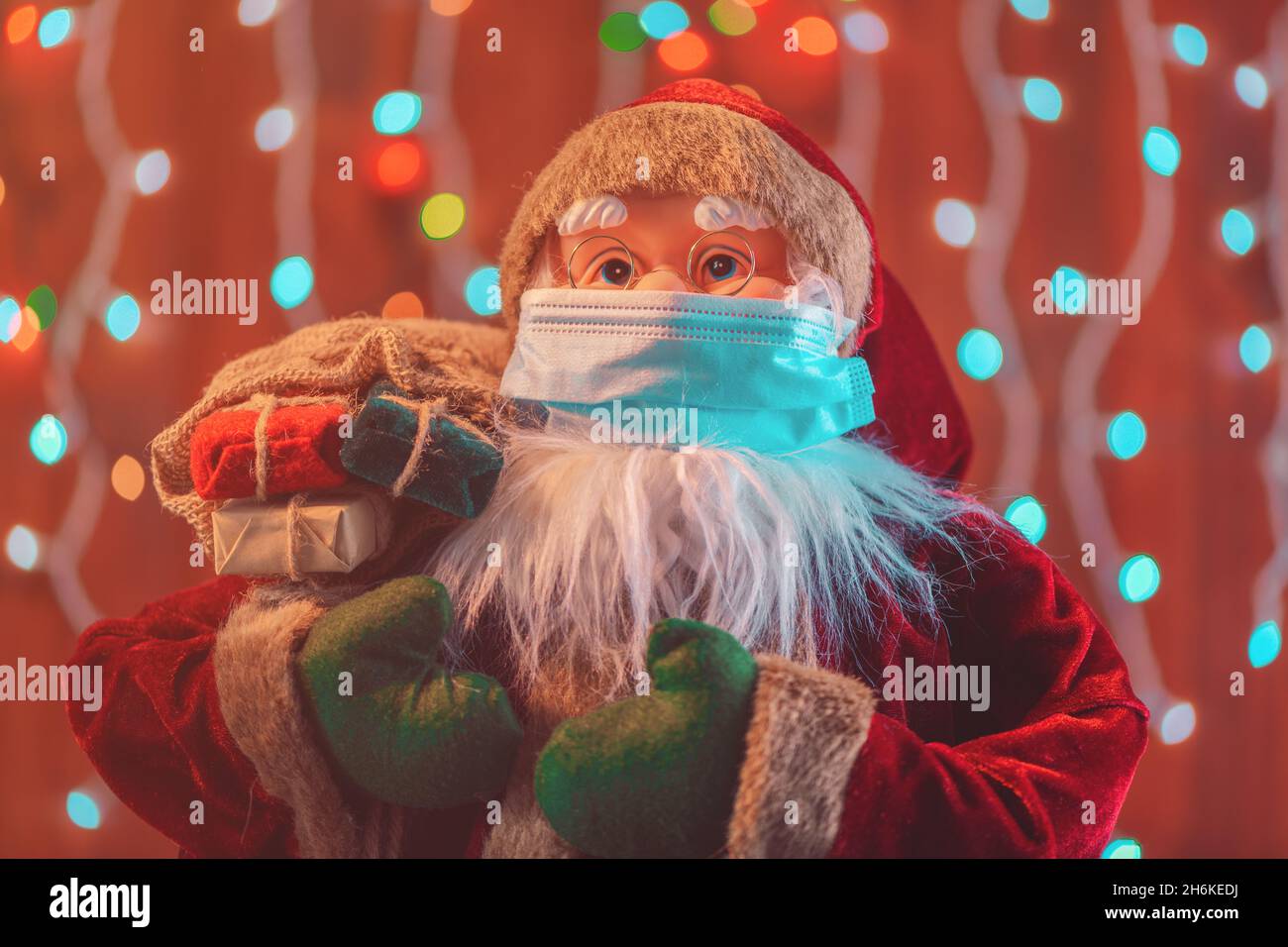 Giocattolo fittizio Babbo Natale con maschera protettiva per pandemie Covid-19, fuoco selettivo Foto Stock