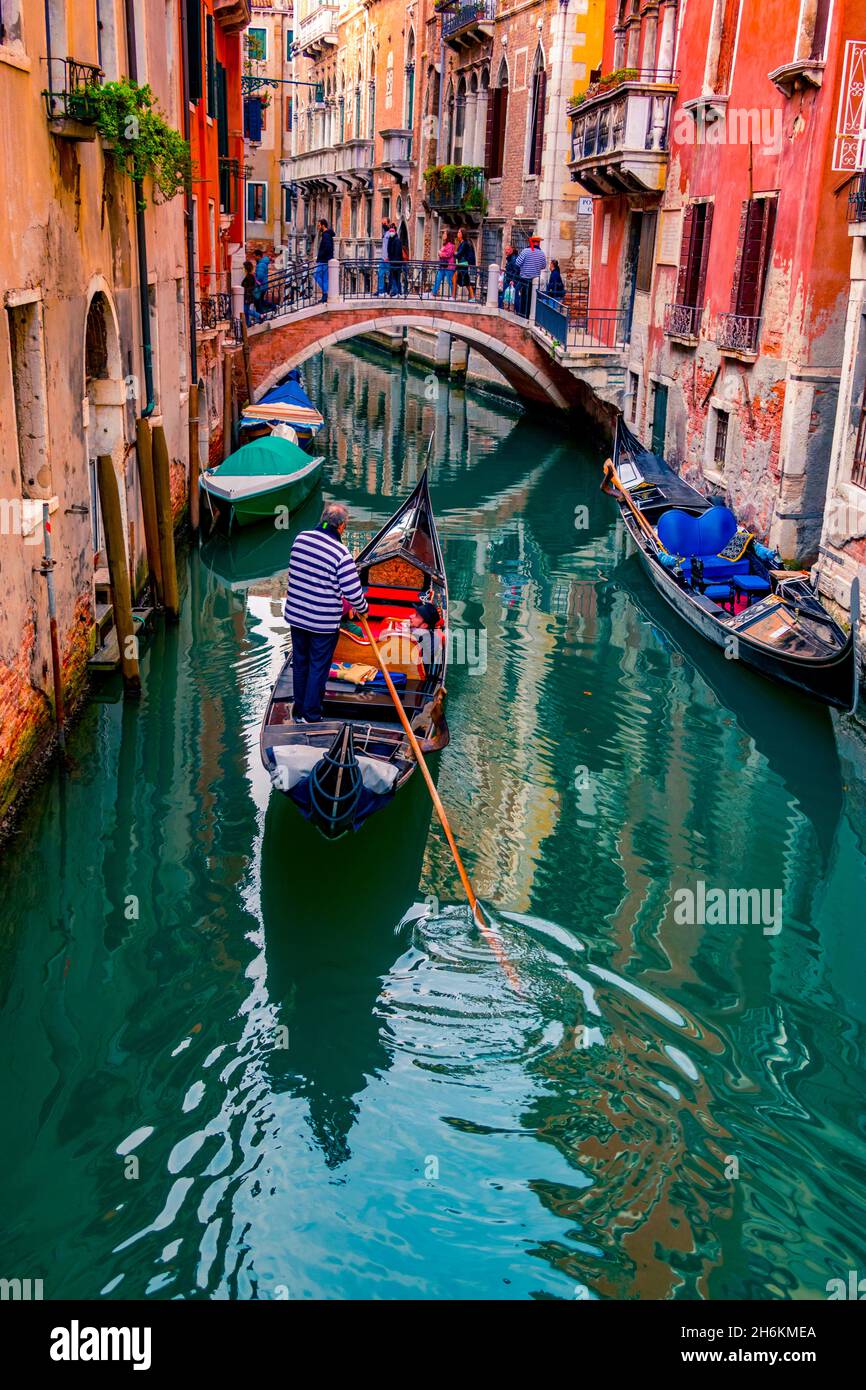 Venezia gondola che percorre un canale piuttosto stretto Venezia Italia Foto Stock