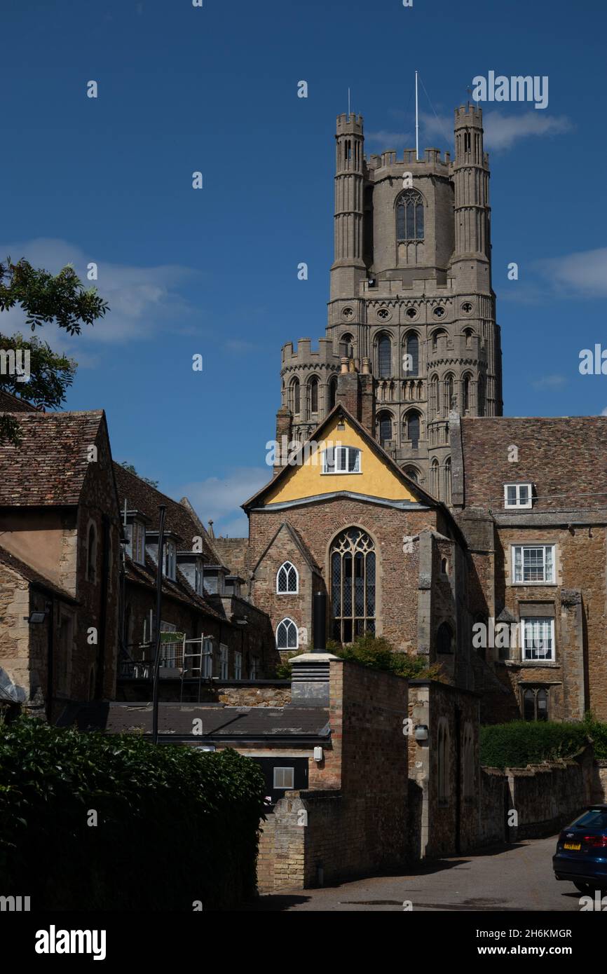Vista sulla strada di vecchie case e edifici intorno alla torre ovest dominante di Ely cattedrale Cambridgeshire Inghilterra Foto Stock