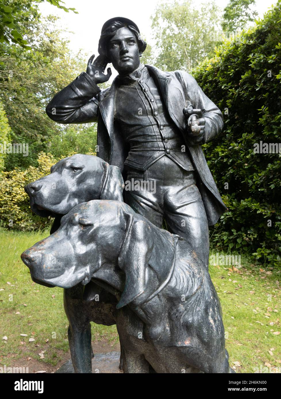 Statua di due cani e cacciatore maschile nel terreno al momento proprietà di fiducia nazionale Anglesey Abbey Lode vicino Cambridge Inghilterra Foto Stock