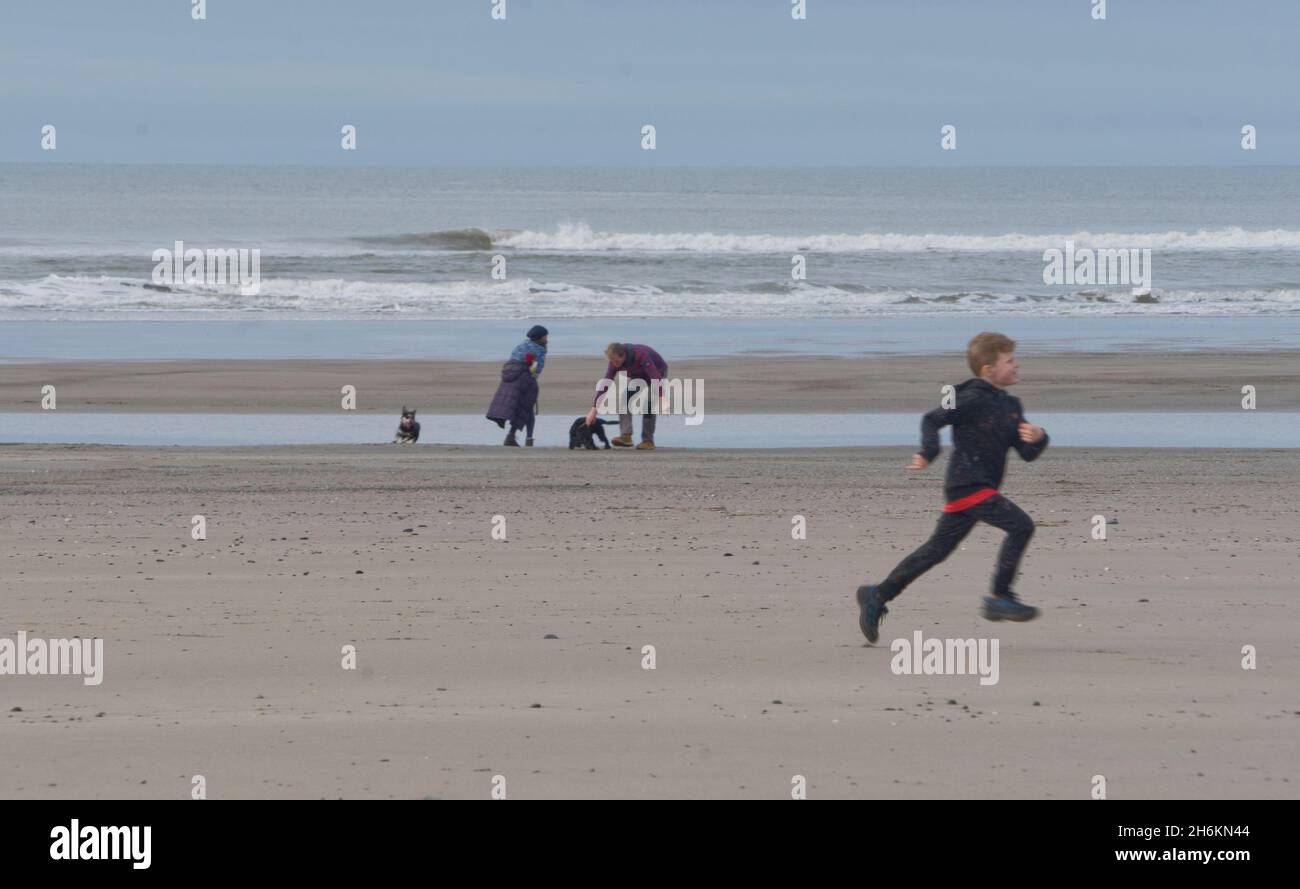 La famiglia si esercita sulla spiaggia a Yinilas, estuario di Borth, Galles, Regno Unito Foto Stock