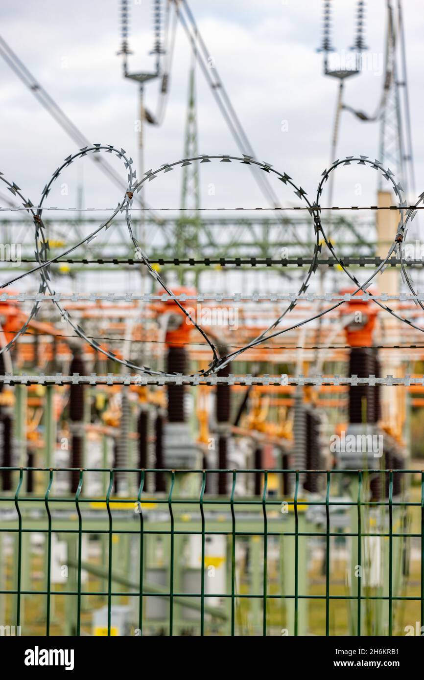 Filo spinato su una recinzione che limita l'ingresso a una sottostazione elettrica Foto Stock