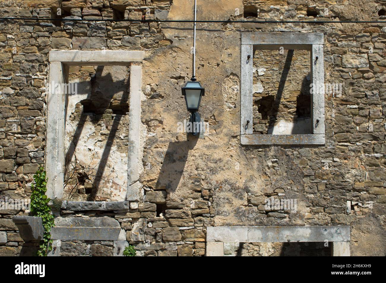 Finestre di una vecchia casa in pietra abbandonata e rovinata in un piccolo villaggio Oprtalj Portole in Istria centrale, Croazia Foto Stock
