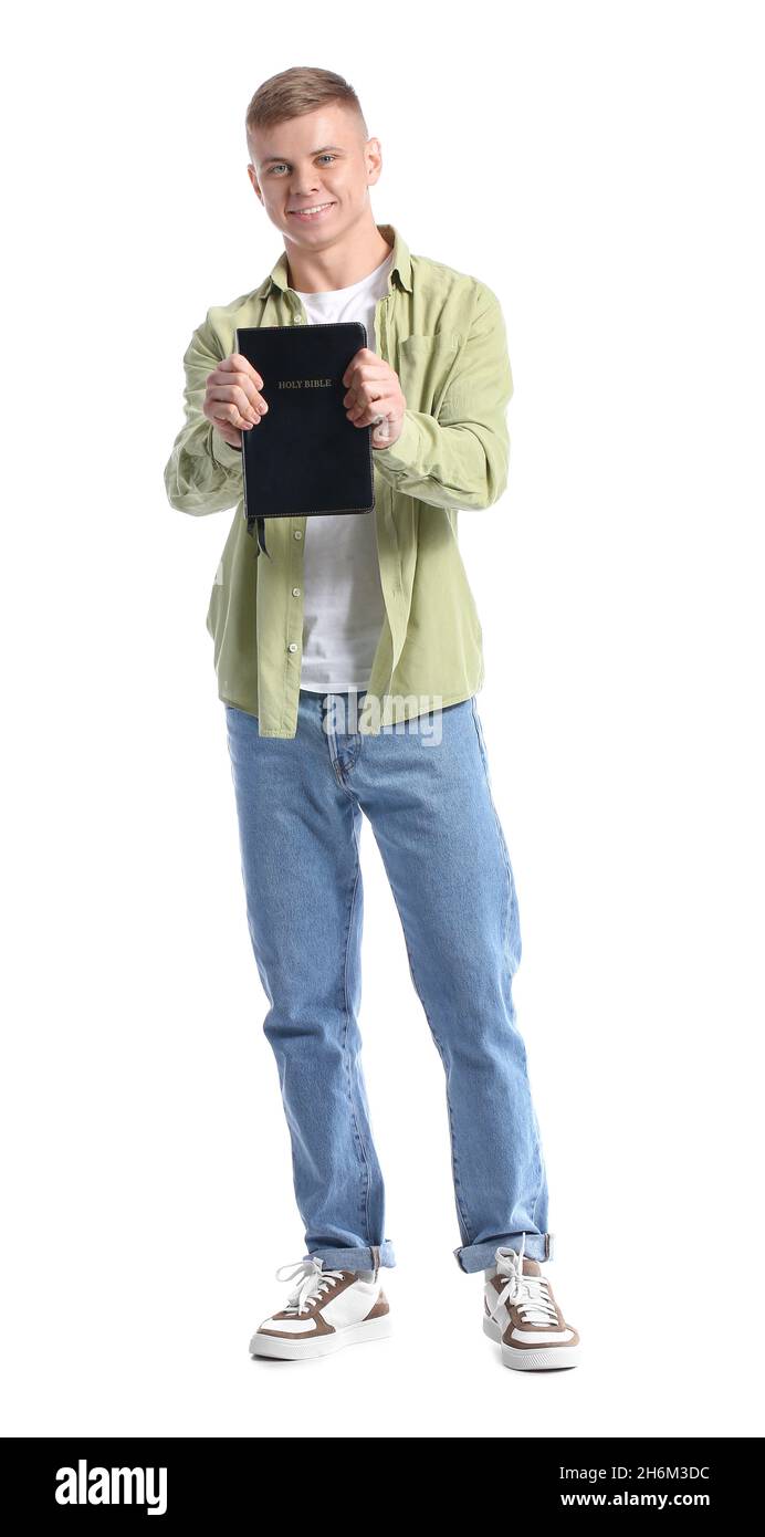 Bel giovane con la Sacra Bibbia su sfondo bianco Foto Stock