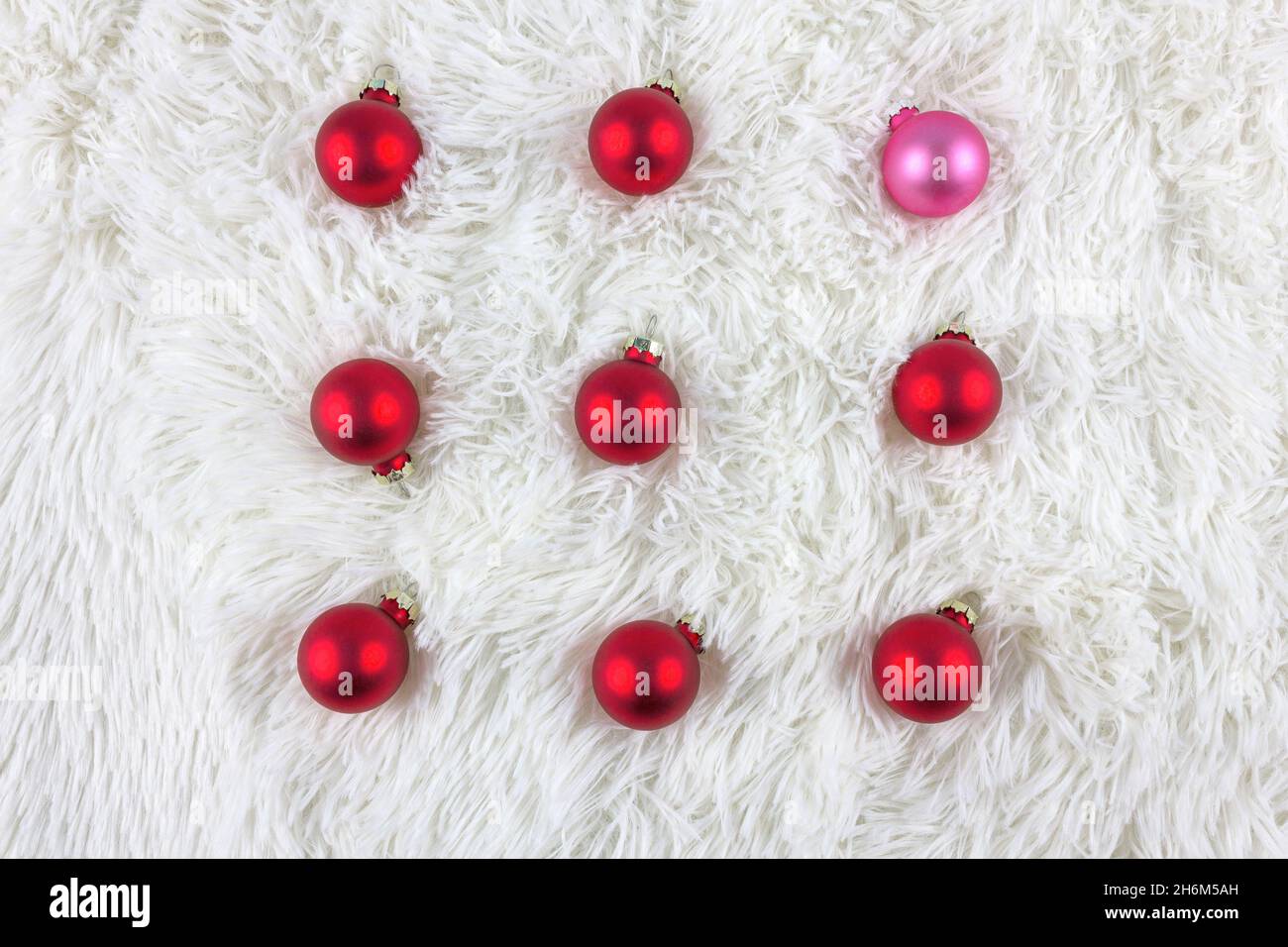 Natale e Capodanno. Palle di Natale su sfondo bianco pelliccia sintetica. Sfondo soffice. Disposizione piatta. Spazio di copia. Foto Stock