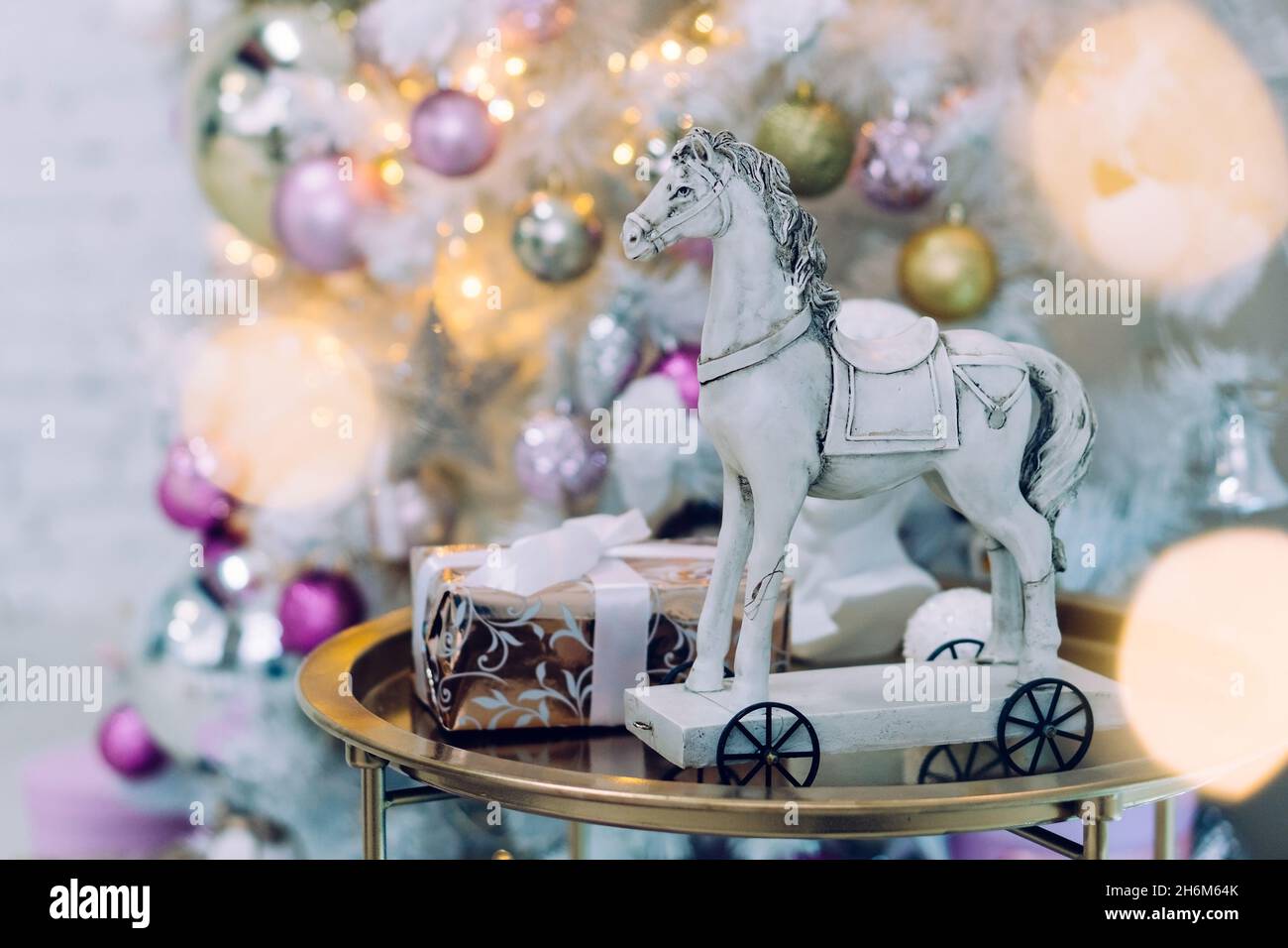 Vintage giocattolo cavallo in legno vicino a scatola regalo. Decorato albero di Natale su sfondo Foto Stock