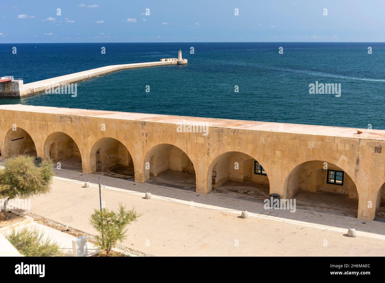 Fort St Elmo casemates, St Elmo Breakwater e St Elmo Lighthouse in background, Valletta, Malta, Europa. Un sito patrimonio dell'umanità dell'UNESCO Foto Stock