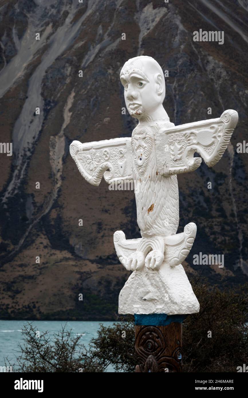 Maori Pou (statua) per commemorare gli insegnamenti di te Maiharoa, Lago Ohau, MacKenzie, Canterbury Sud, Isola del Sud, Nuova Zelanda. Ben Ohau in lontanamento Foto Stock