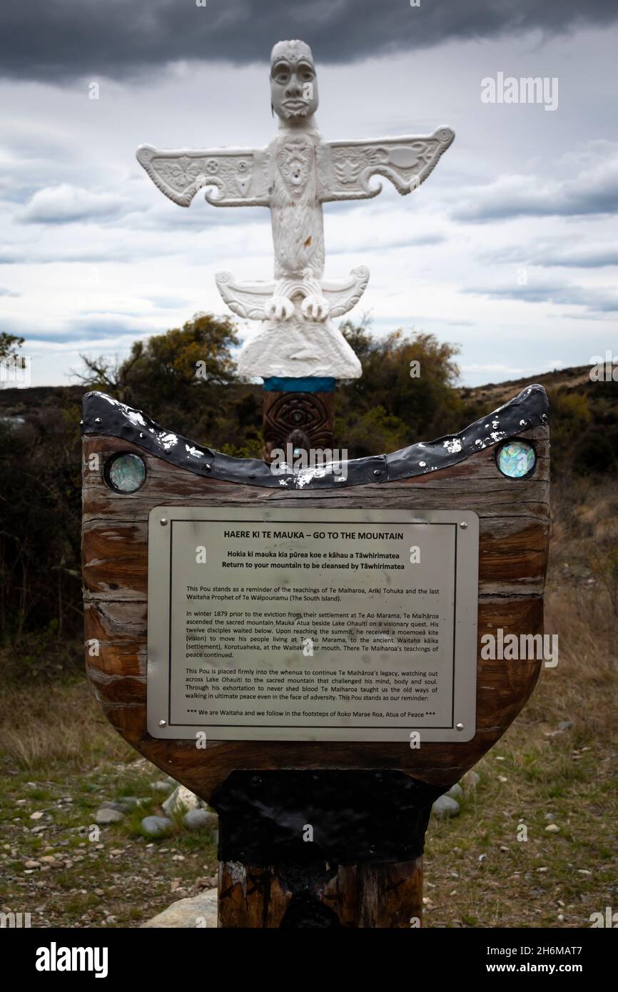 Maori Pou (statua) per commemorare gli insegnamenti di te Maiharoa, Lago Ohau, MacKenzie, Canterbury Sud, Isola del Sud, Nuova Zelanda. Ben Ohau in lontanamento Foto Stock