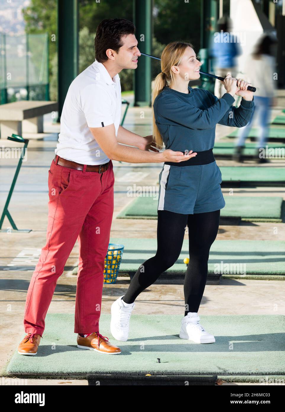 L'addestratore di golf insegna un gioco della donna Foto Stock