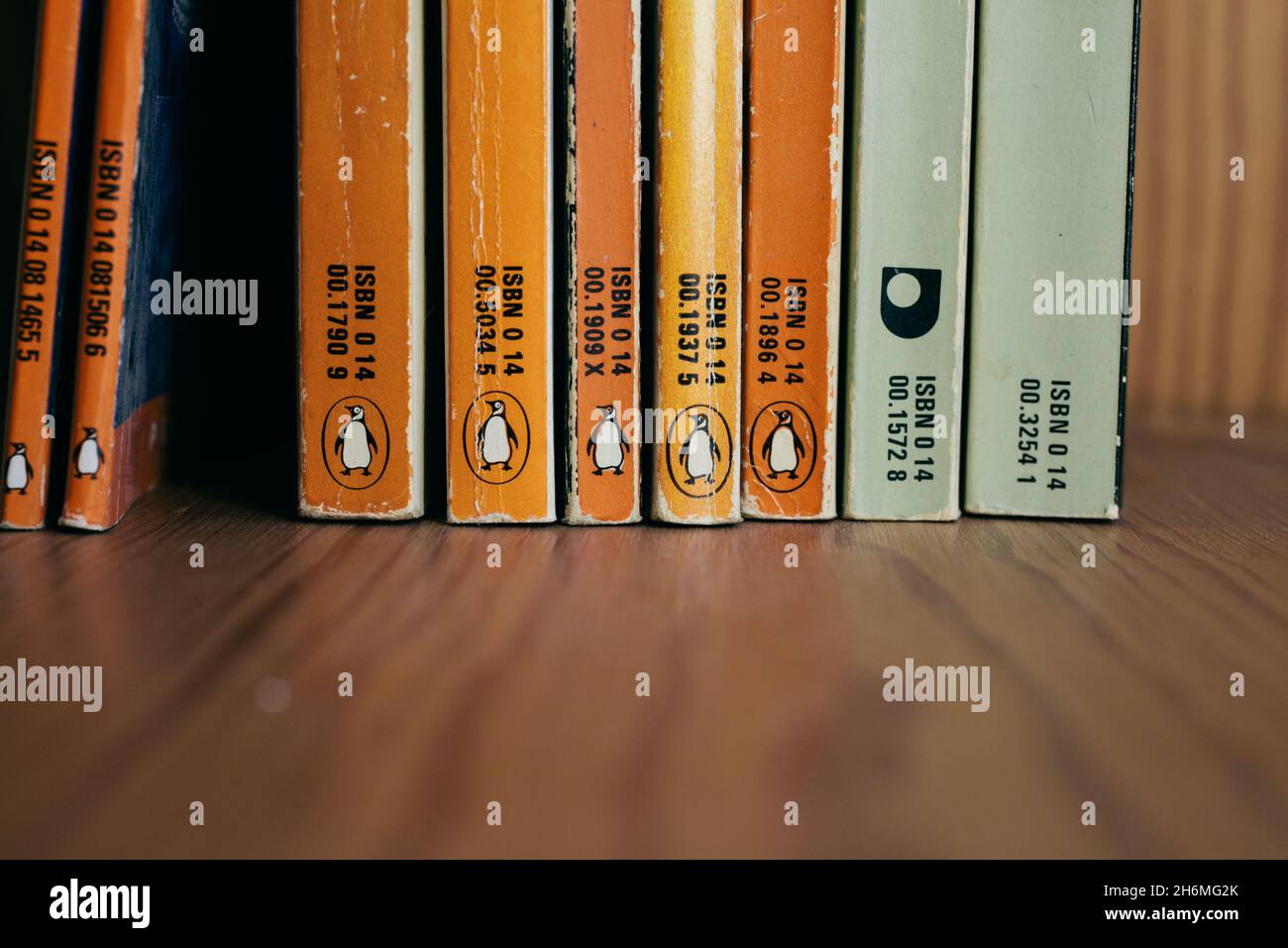Collezione di vecchi libri di pinguini su scaffale in legno. Pinguini d'epoca. Foto Stock
