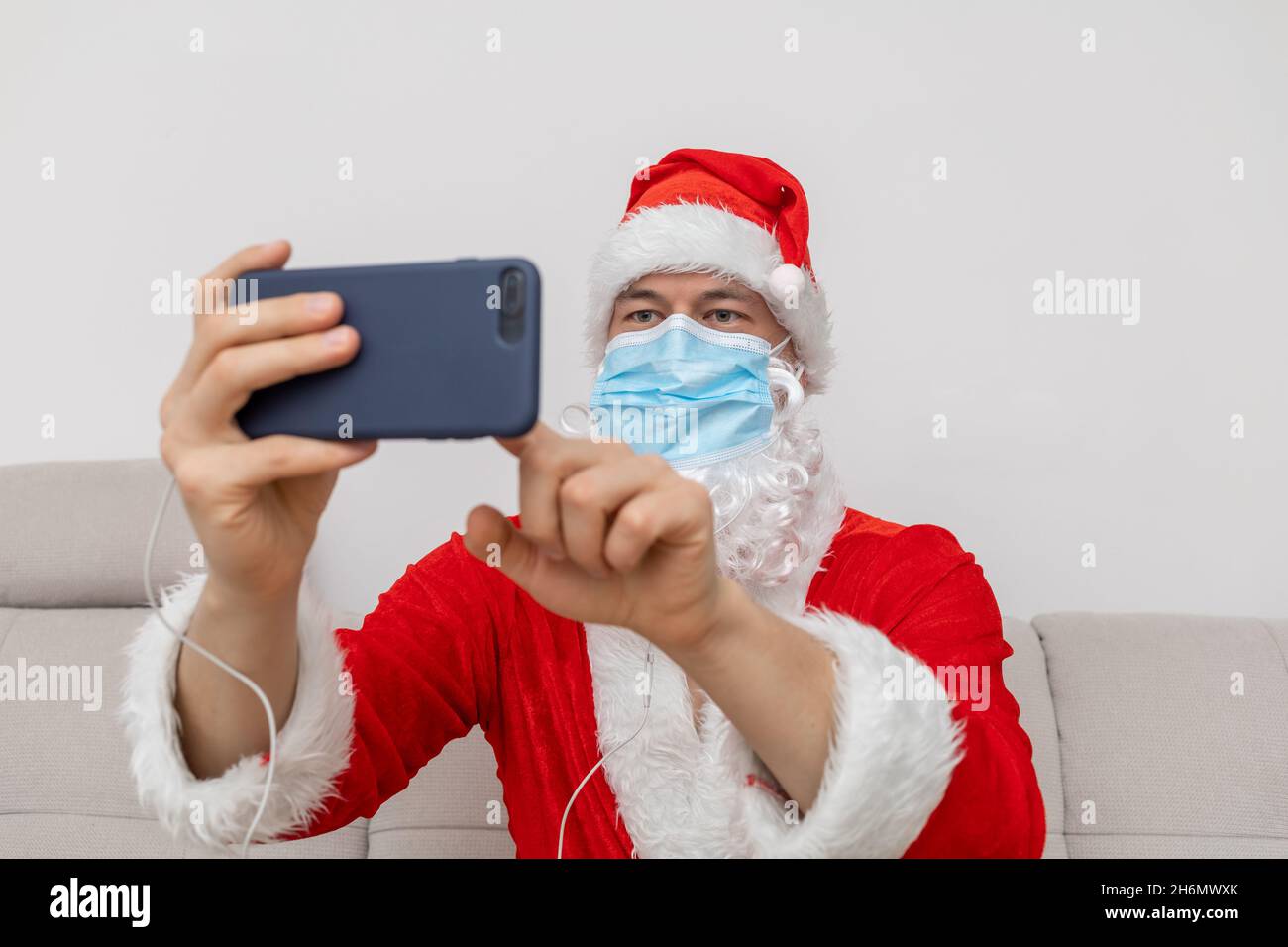 Vestito come Babbo Natale che parla tramite videoconferenza Foto Stock