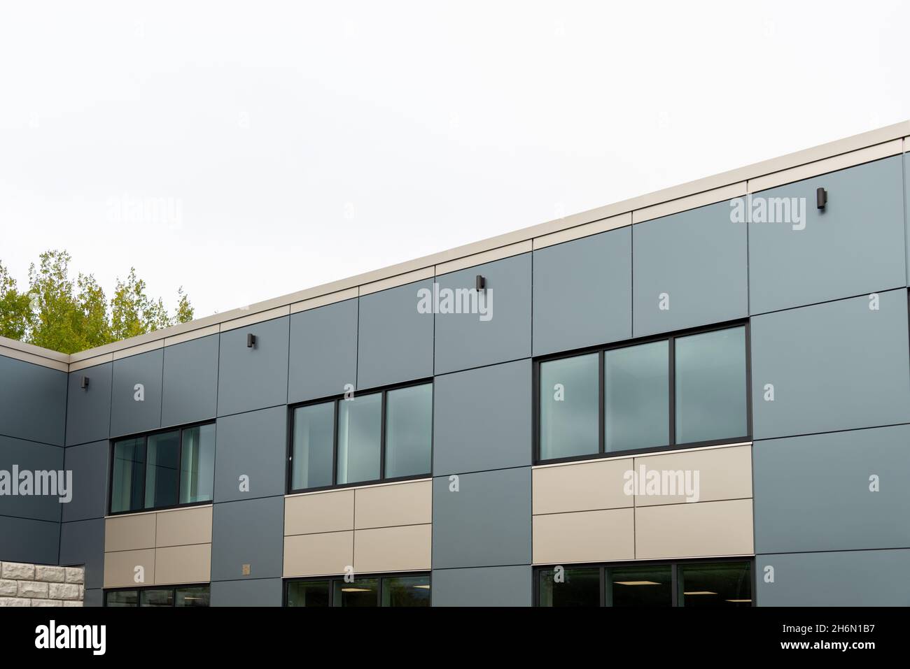 La parete esterna di un edificio contemporaneo di stile commerciale con pannelli compositi in alluminio e finestre in vetro. L'edificio futuristico Foto Stock
