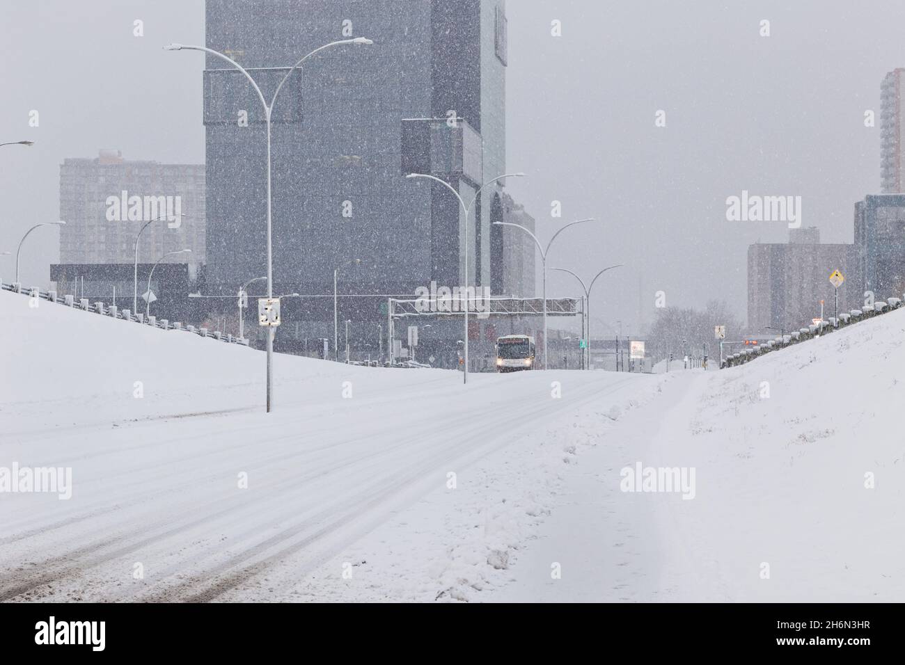 Un autobus percorre una strada innevata a Longueuil, Quebec, Canada Foto Stock