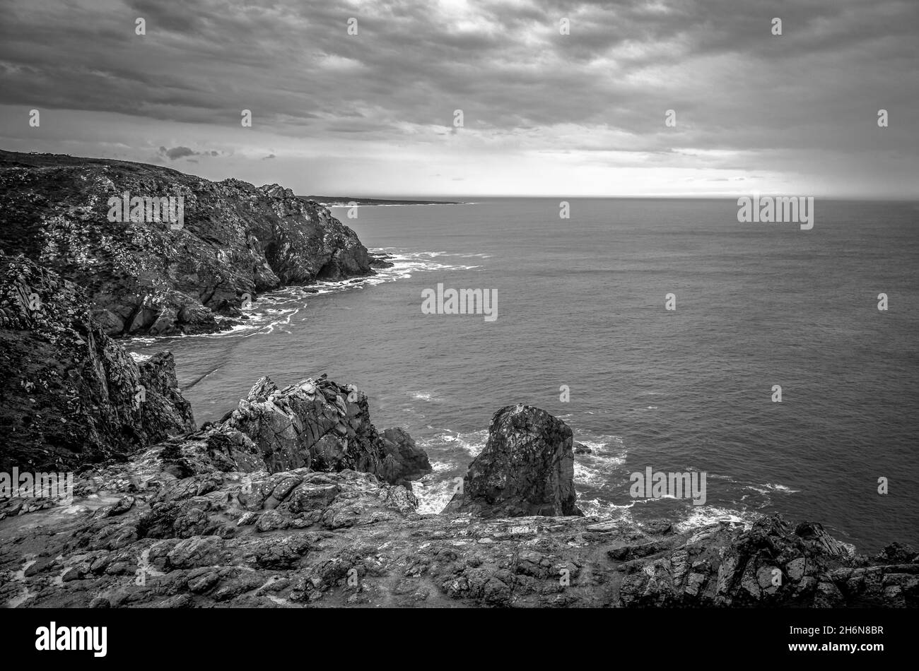 Massi di granito e scogliere lungo la costa di Cabo da Roca. Lisbona, Portogallo. Bianco e nero. Foto Stock