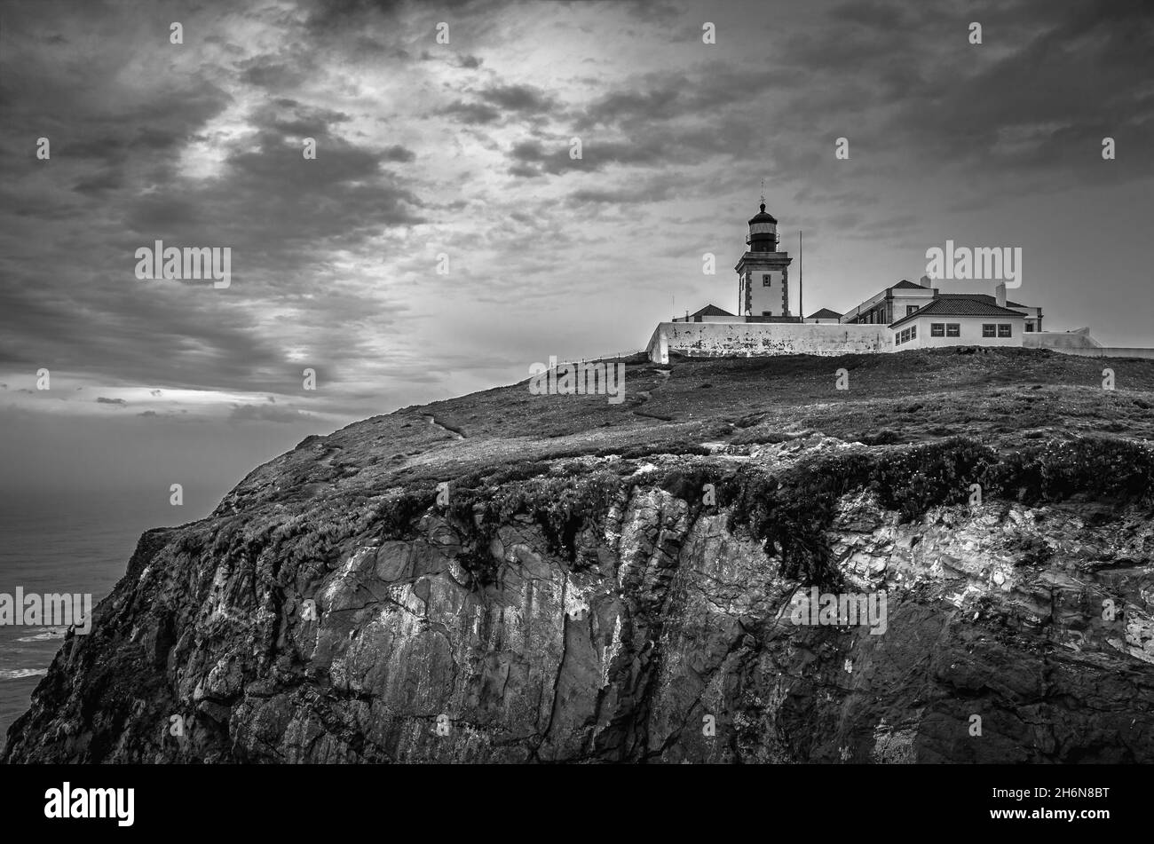 Faro di Cabo da Roca che si affaccia sul promontorio verso l'Oceano Atlantico. Lisbona, Portogallo. Bianco e nero. Foto Stock
