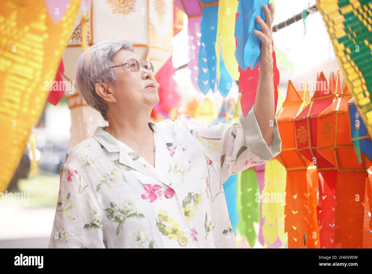 anziano anziano asiatico con appendere carta decorativa festiva lanterna Foto Stock