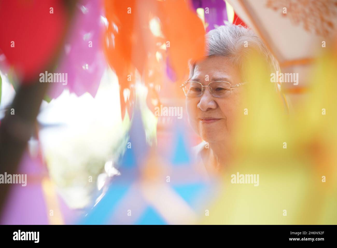 anziano anziano asiatico con appendere carta decorativa festiva lanterna Foto Stock