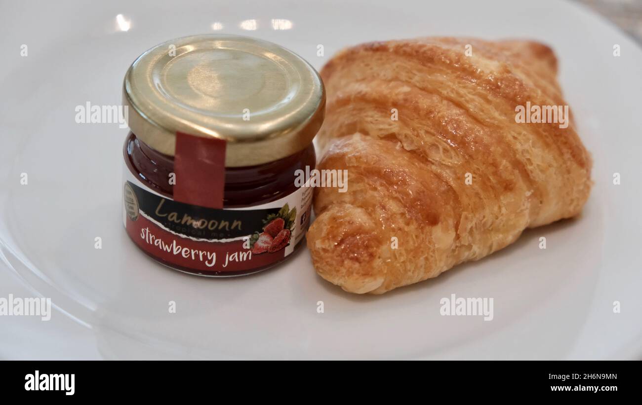 Un vasetto di marmellata e una pasticceria croissant francese Foto Stock