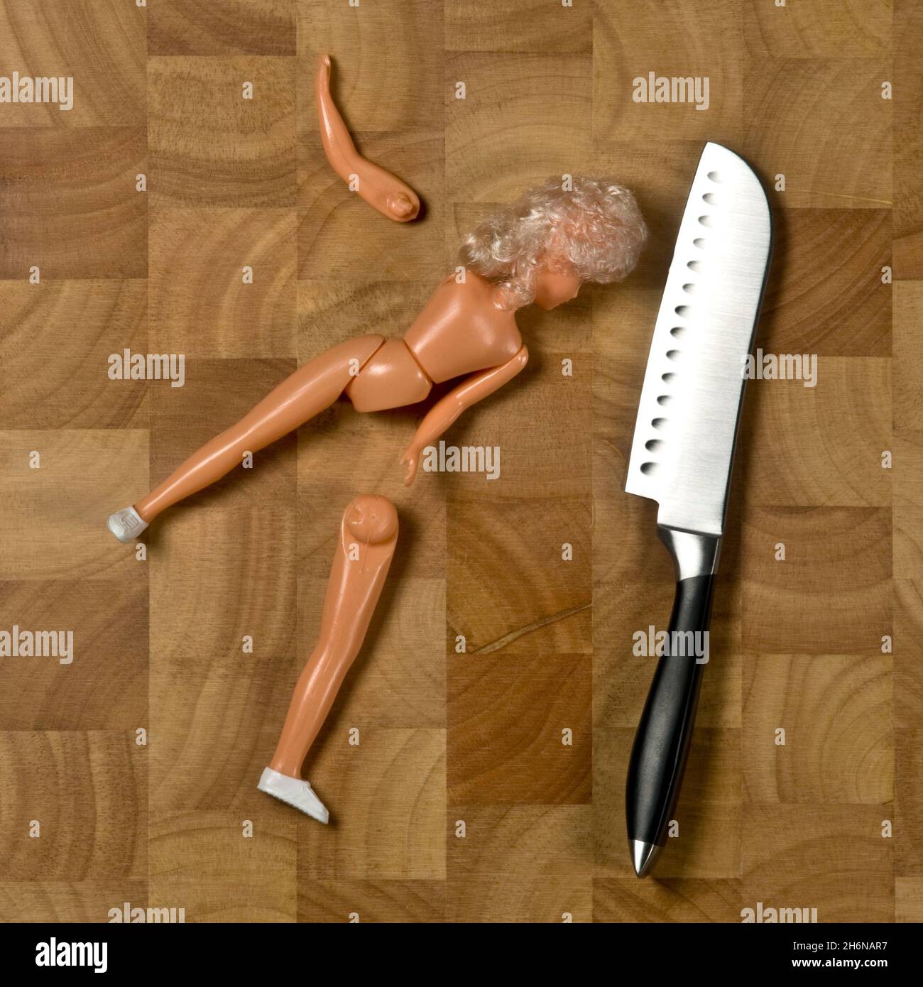 Bambola per bambini con gamba tagliata, con coltello sul blocco tritatutto Foto Stock