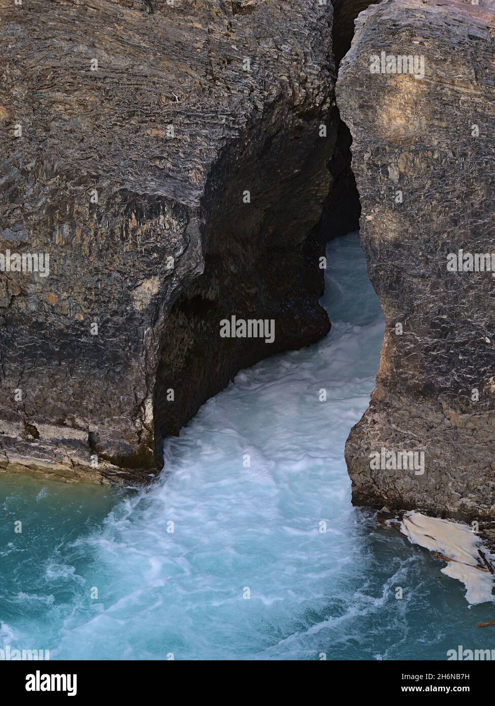 Vista ravvicinata del torrente Kicking Horse River che scorre attraverso lo stretto gap tra rocce erose al Natural Bridge nel Parco Nazionale di Yoho, Canada. Foto Stock