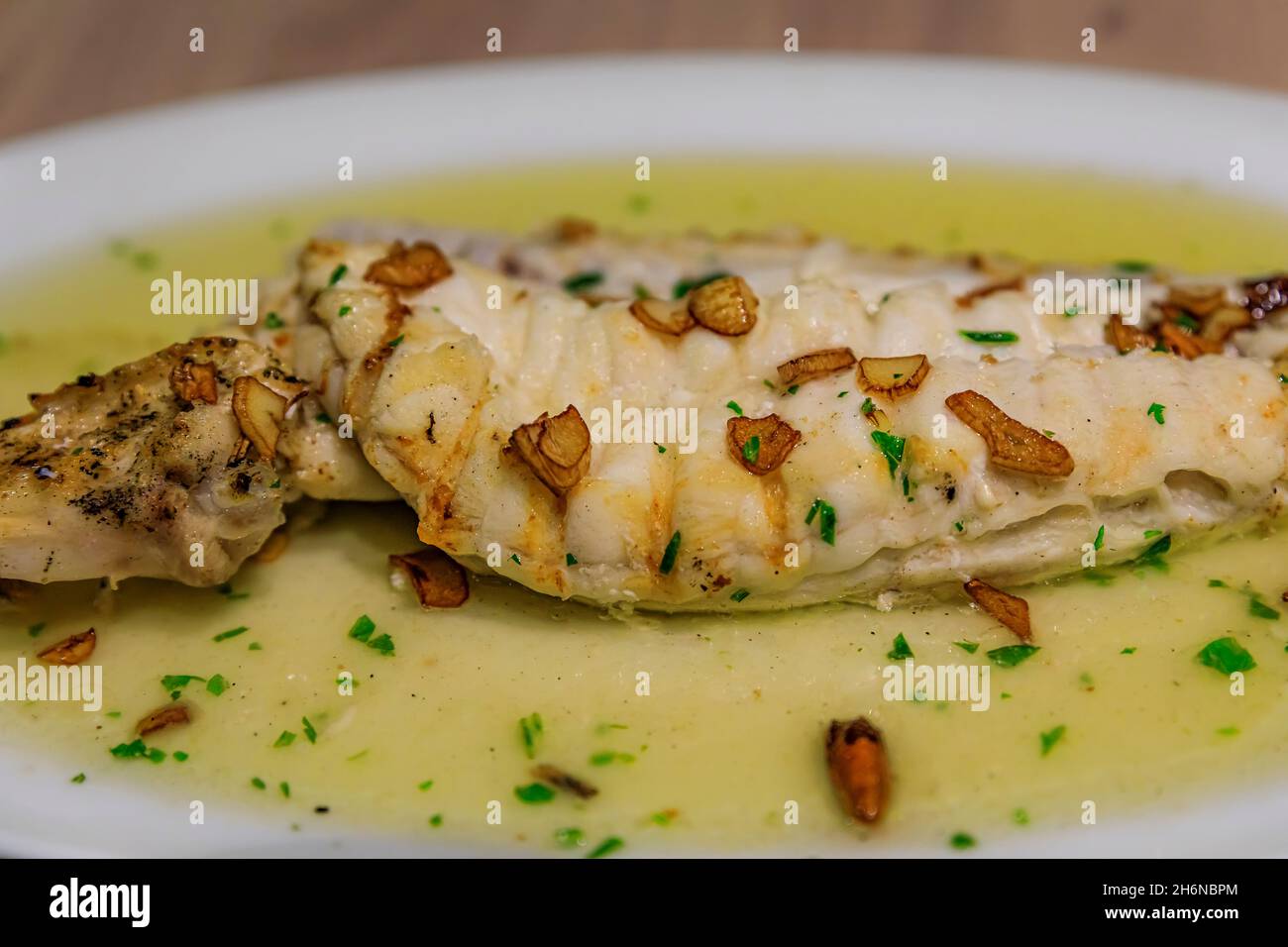 Bacalao con salsa al pil, piatto basco tradizionale con merluzzo salino in olio infuso all'aglio con guindilla peperoncino secco, in un ristorante a Pamplona, Spagna Foto Stock