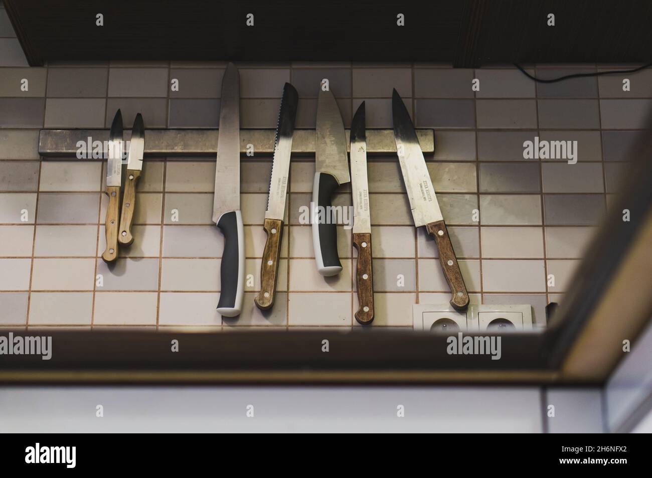 POZNAN, POLONIA - 09 giugno 2018: Un set di coltelli da cucina affilati appesi su un magnete da parete, Poznan, Polonia Foto Stock