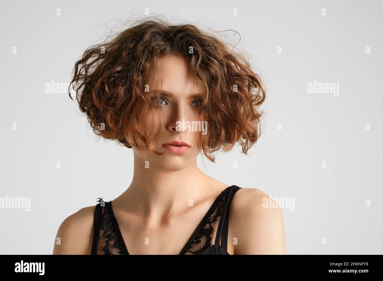 Ritratto closeup di giovane donna con capelli ricci corti Foto Stock