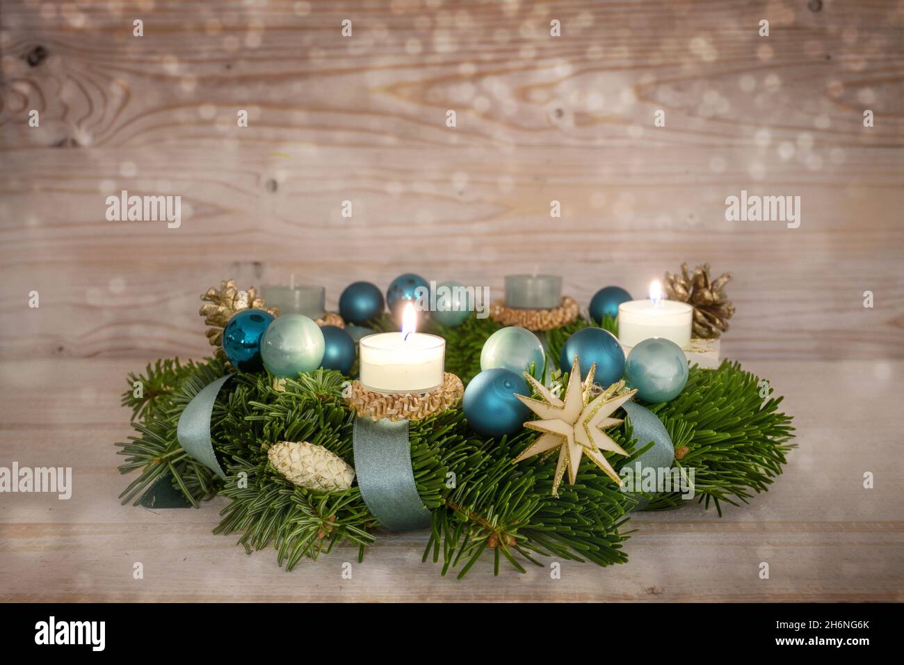 Serie numero due della corona dell'avvento con candele illuminate, baubles blu di Natale e decorazione su uno sfondo rustico di legno nevoso, quarta domenica, spazio copia Foto Stock