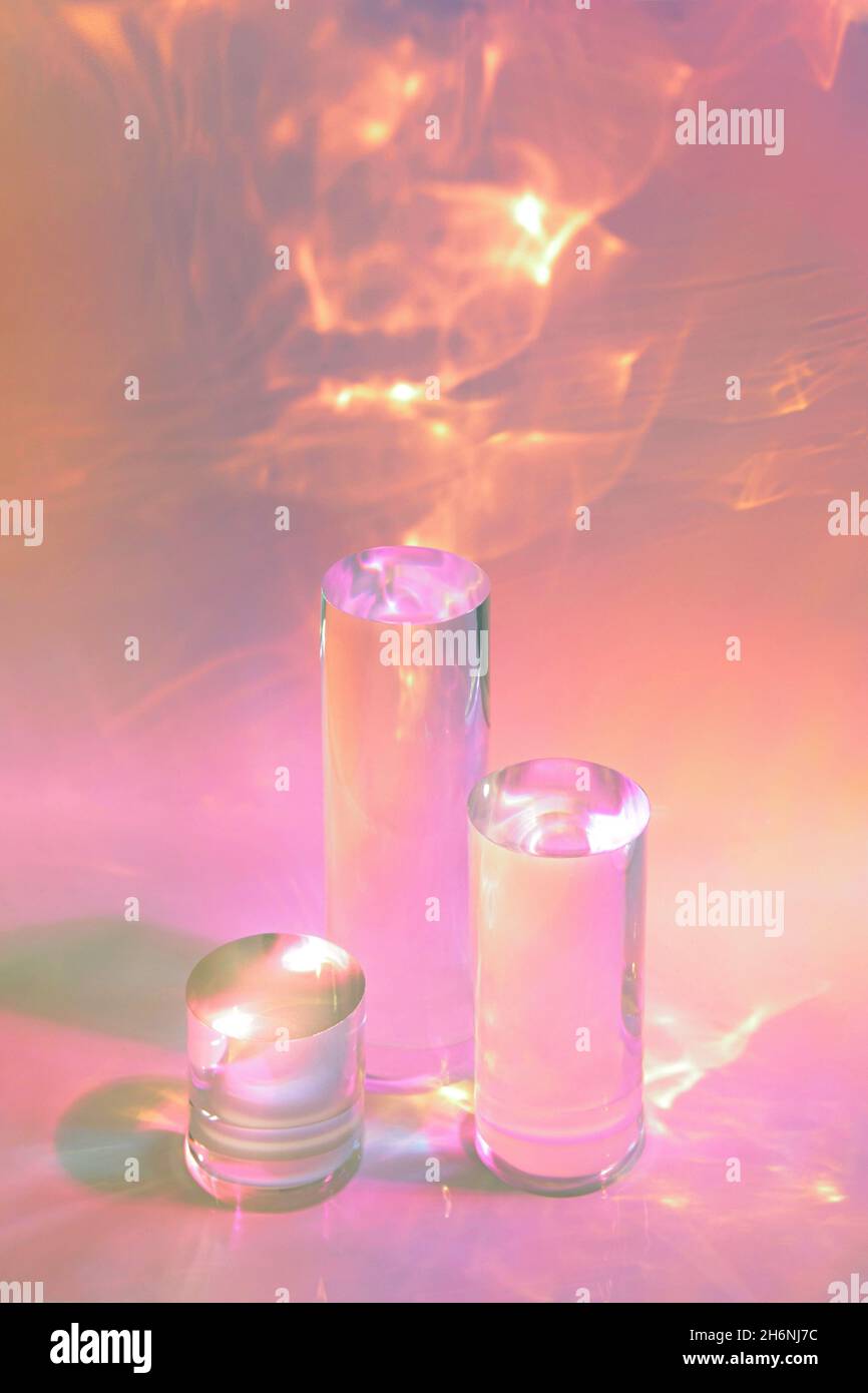tre podi in vetro chiaro su sfondo rosa pastello Foto Stock