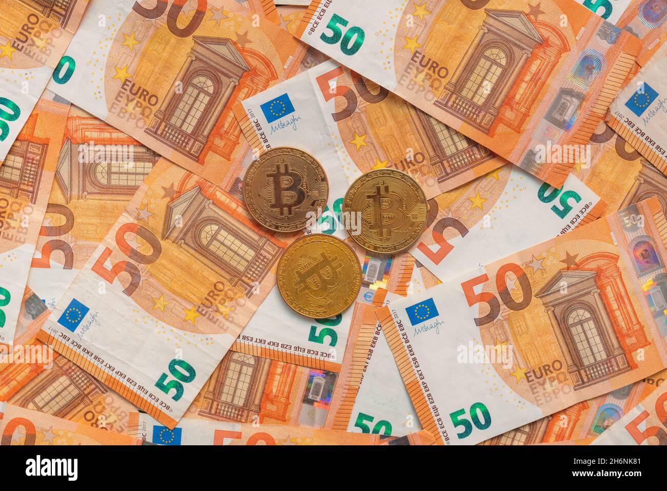 Monete in Bitcoin e banconote in euro per il cambio valuta, vista dall'alto Foto Stock