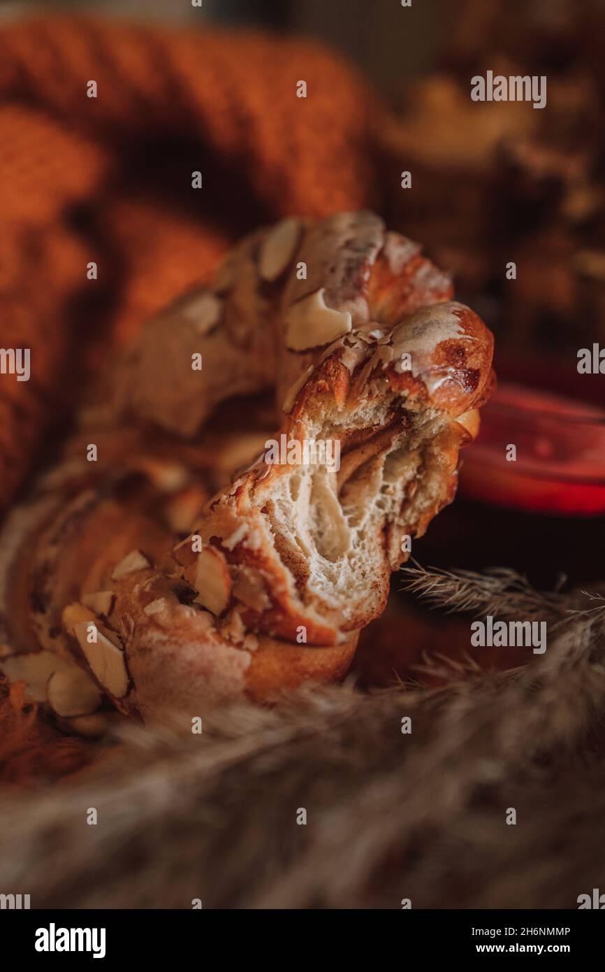 Frolla dolce con mandorle su un tessuto a maglia d'arancia con fiori secchi d'autunno. Casa accogliente ancora vita Foto Stock