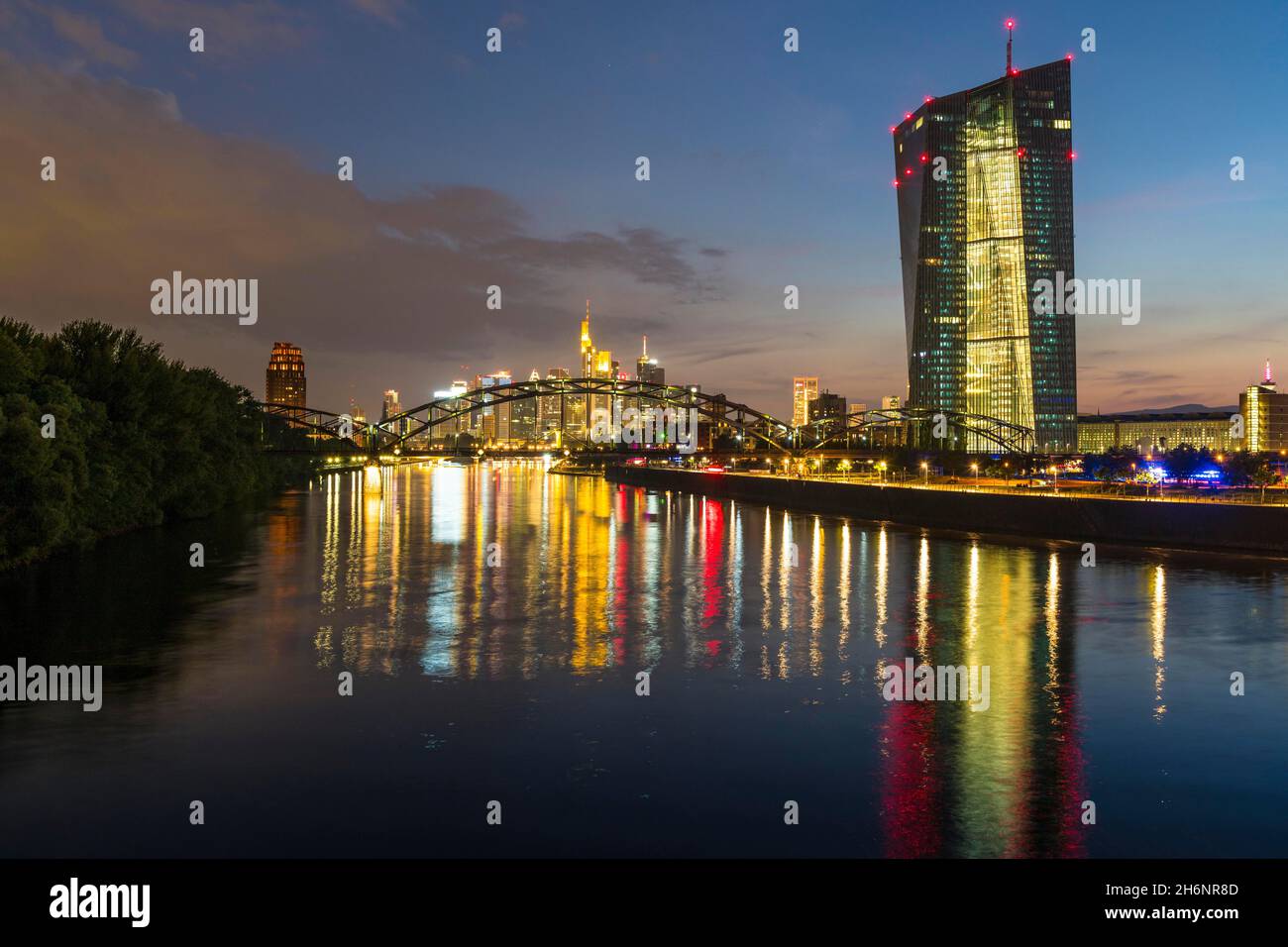 Banca Centrale europea illuminata, BCE e skyline colorato di Francoforte riflessi nel fiume meno durante il tramonto tardivo da Arthur-von-Vineyard-Steg Foto Stock
