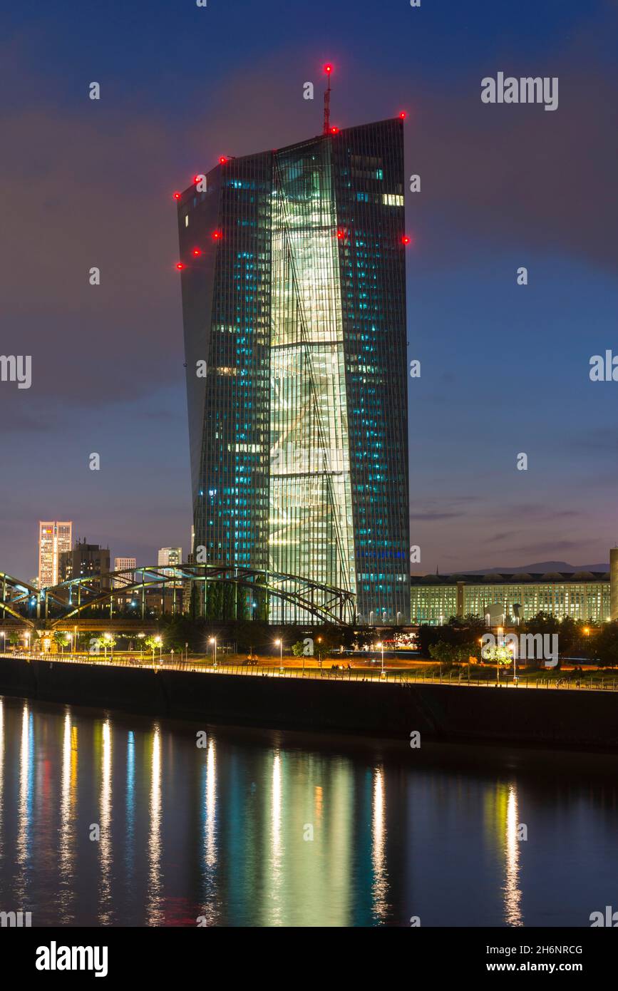 Banca centrale europea illuminata, la BCE si è riflessa nel fiume meno durante il tramonto tardivo da Arthur-von-Vineyard-Steg, Francoforte sul meno, Assia, Germania Foto Stock