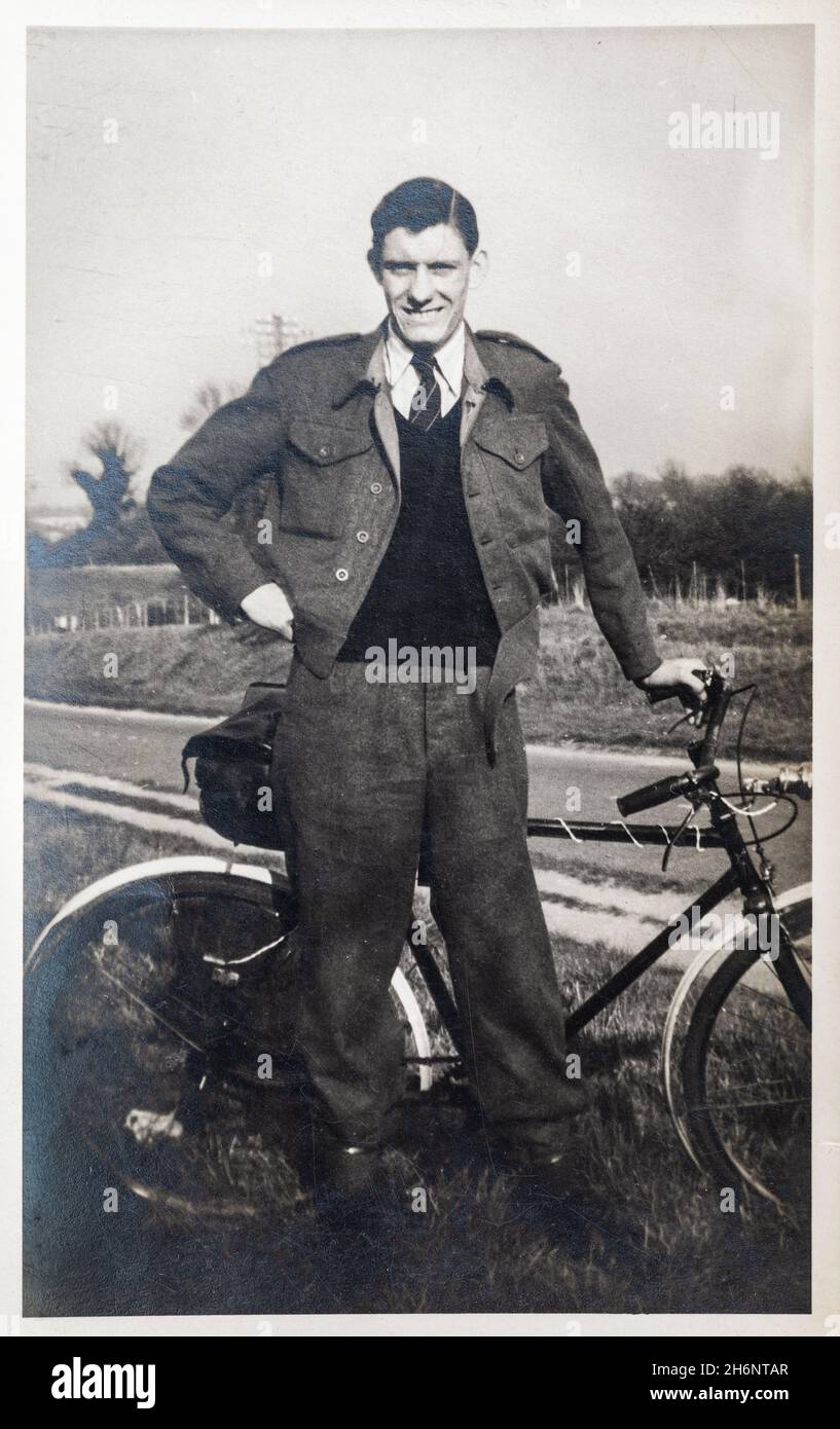 Giovane uomo fuori per un giro in bicicletta. Foto d'epoca di un adolescente, circa 18 anni, con una bicicletta a spinta, in piedi sul lato di una strada. Bianco e nero. Circa 194 Foto Stock