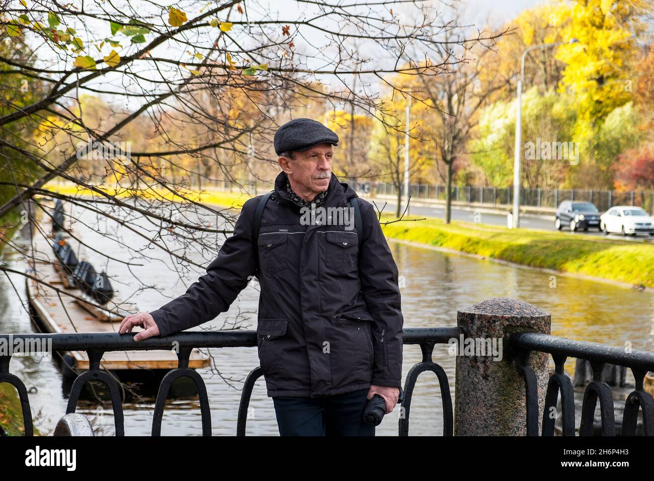 Anziano pensionato si trova in una bella giornata d'autunno nel parco cittadino Foto Stock