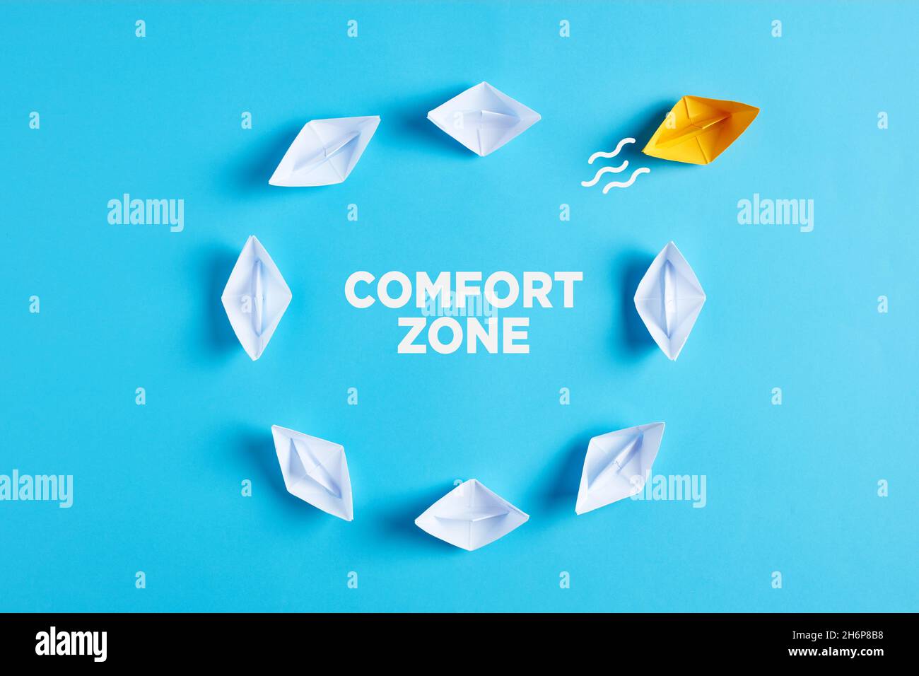 Uscire dal concetto di zona comfort. Una barca di carta interrompe il ciclo di routine. Foto Stock