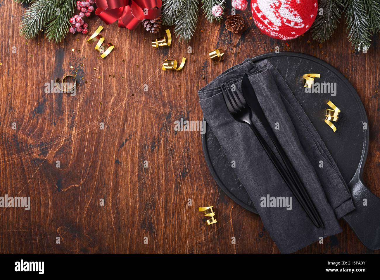 Tabella di Natale impostazione colore nero con alberi di abete di Natale rami, palle di Natale e pan di zenzero su vecchio sfondo di legno per i saluti di Natale. Mer Foto Stock